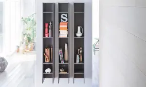 Scaffali grigi con oggetti decorativi, piante e libri, che creano un effetto camino ventilazione naturale.