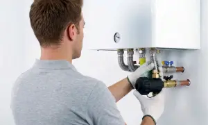 Tecnico installa componente su caldaia, assicurando la garanzia condizionatori.