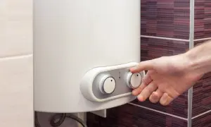 Mano che regola la temperatura di una caldaia a corrente.