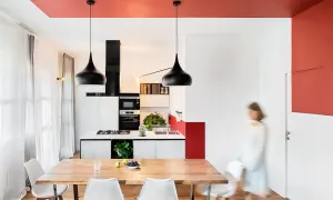 Soffitto rosso acceso per un tocco audace, un'idea pittura soffitto che valorizza la cucina moderna con lampade nere e arredi minimalisti.