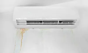 Condizionatore perde acqua nel muro, lasciando macchie di umidità e ruggine.