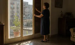 Donna chiude le persiane per capire come rinfrescare casa senza condizionatore, creando un'ombra accogliente.