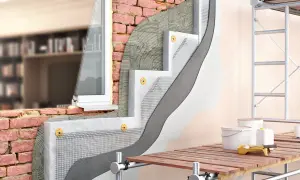 Sezione di muro che illustra la differenza tra coibentazione e cappotto termico, con strati di isolante, rete e intonaco.