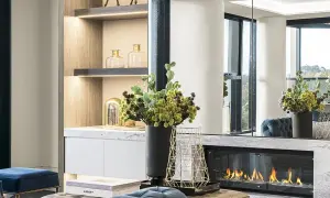 Un elegante camino bioetanolo come funziona: fiamme vive su un letto di sassi bianchi, con decorazioni moderne e arredi di lusso.