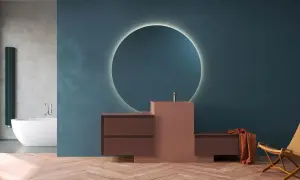 Mobile bagno moderno con lavabo integrato in materiale corian, specchio circolare retroilluminato e finiture in legno.