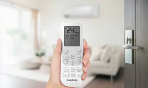 Mano che tiene il telecomando di un condizionatore Samsung. Il display mostra 24°C, Auto, Cool, Dry, Fan, Heat. Il significato di un condizionatore potente è il comfort.