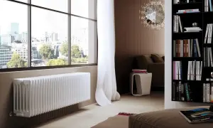 Un elegante termosifone bianco sotto una grande finestra con vista sulla città.