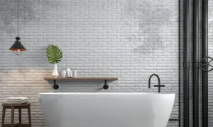 Bagno moderno con vasca bianca, mattoni a vista e tubi industriali neri. Ottime idee per coprire tubi a vista con stile.