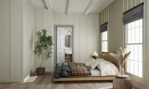 Letto in legno con coperte, posizionato di fianco alla porta aperta che conduce al bagno. Pianta in vaso e finestra con luce naturale.