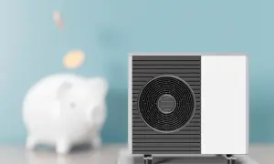 Scaldacqua a pompa di calore: svantaggi e risparmio. Un salvadanaio a forma di maialino con monete che cadono, accanto a un'unità esterna.