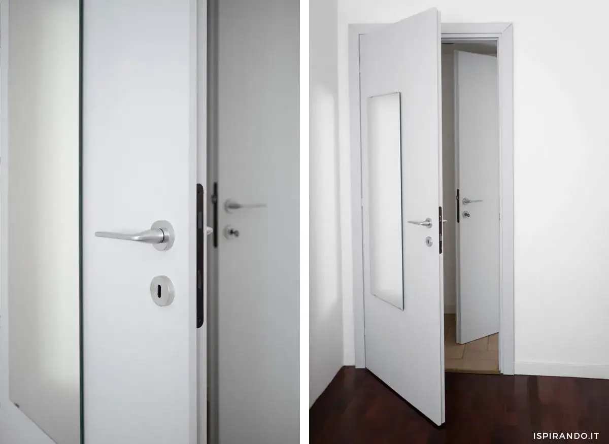 Dettaglio di porte interne di bianco, con maniglie argentate e serrature. Una porta è socchiusa, rivelando un'altra porta identica.