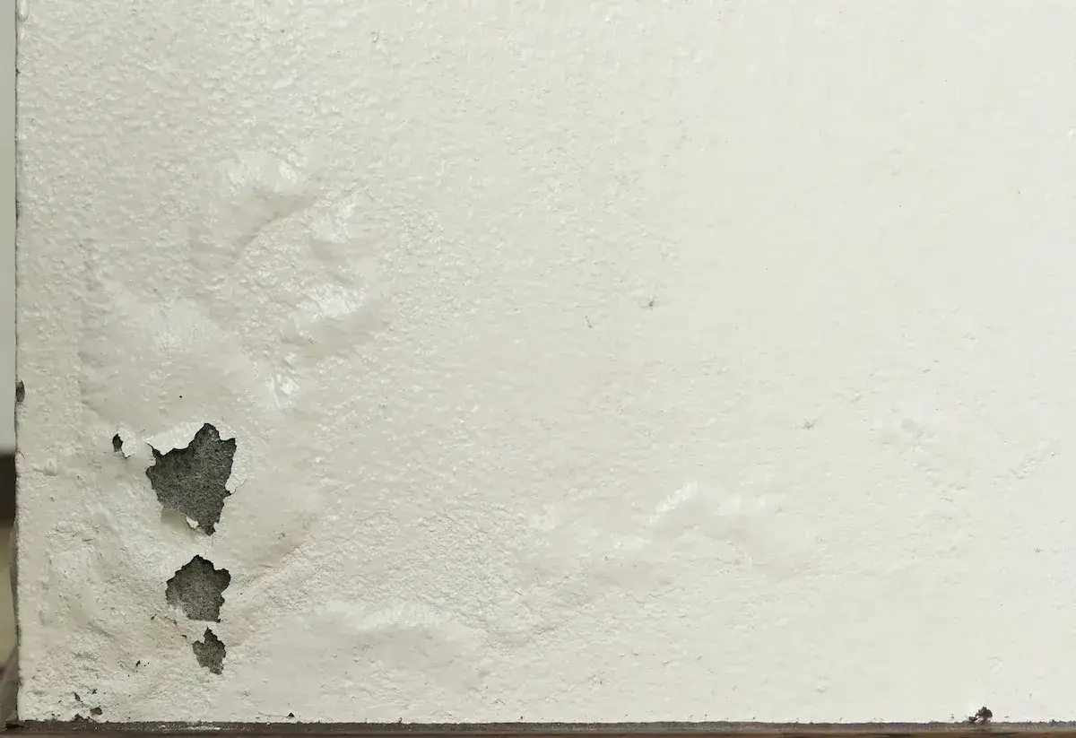Muro che sfarina, con macchie di umidità e intonaco scrostato. Urge trovare rimedi prima che il danno peggiori.