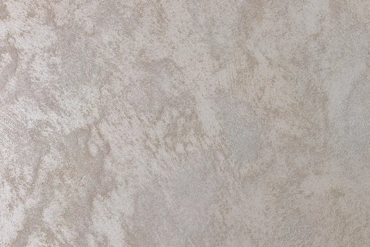 Superficie di intonaco spugnato con sfumature chiare e texture materica, che evoca un effetto naturale e raffinato.